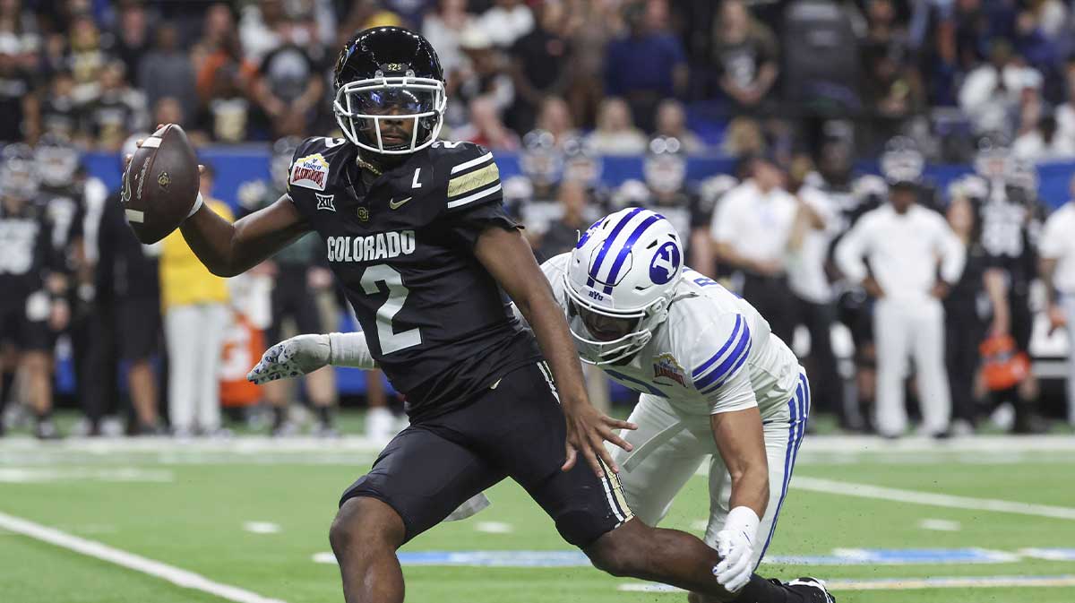 Dec 28, 2024; San Antonio, TX, USA; Colorado Buffaloes quarterback Shedeur Sanders (2) attempts to avoid a tackle by Brigham Young Cougars safety Raider Damuni (3) during the second quarter at Alamodome.