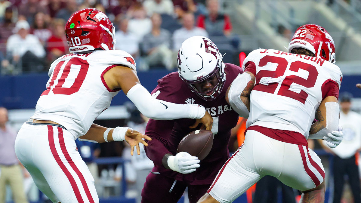 Texas A&M Aggies defensive lineman Shemar Stewart (4) causes a fumble between Arkansas Razorbacks quarterback Taylen Green (10) and Arkansas Razorbacks running back Ja'Quinden Jackson (22) during the first half at AT&T Stadium.