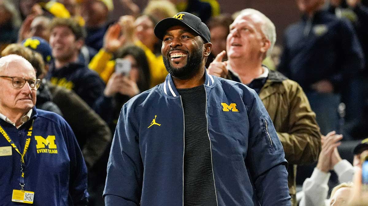Michigan football head coach Sherron Moore smiles at fans during the first half against Iowa at Crisler Center