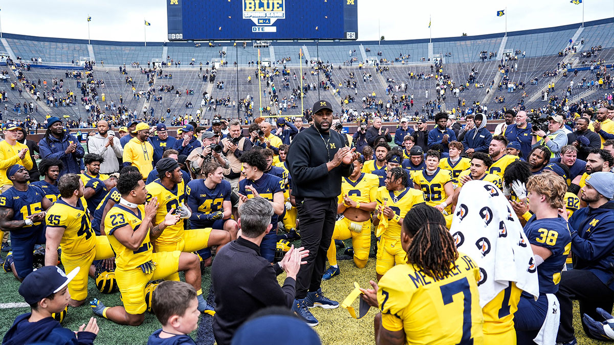 Michigan head coach Sherrone Moore, center, speaks to players after the spring game at Michigan Stadium
