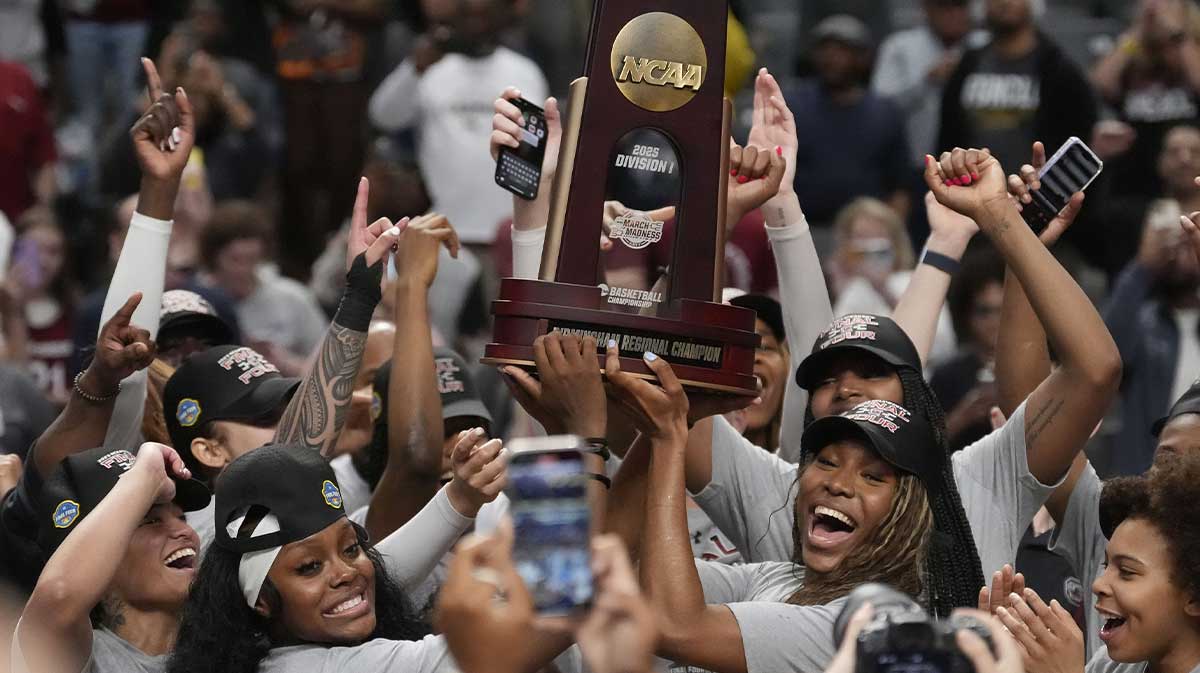 South Carolina women's basketball players celebrate with the Regional trophy after their Elite 8 win against the Duke Blue Devils at Legacy Arena.