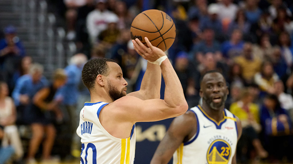 Golden State Warriors guard Stephen Curry (30) shoots the ball as Golden State Warriors forward Draymond Green (23) looks on against the LA Clippers during the second quarter at Chase Center.
