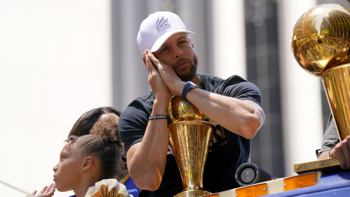 Golden State Warriors guard Stephen Curry poses with the NBA Finals Most Valuable Player Award trophy during the Warriors championship parade in downtown San Francisco.