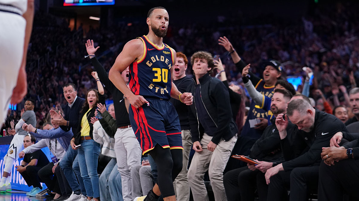 Golden State Warriors guard Stephen Curry (30) hits a clutch three pointer against as Denver Nuggets head coach Michael Malone lowers his head in the third period at Chase Center