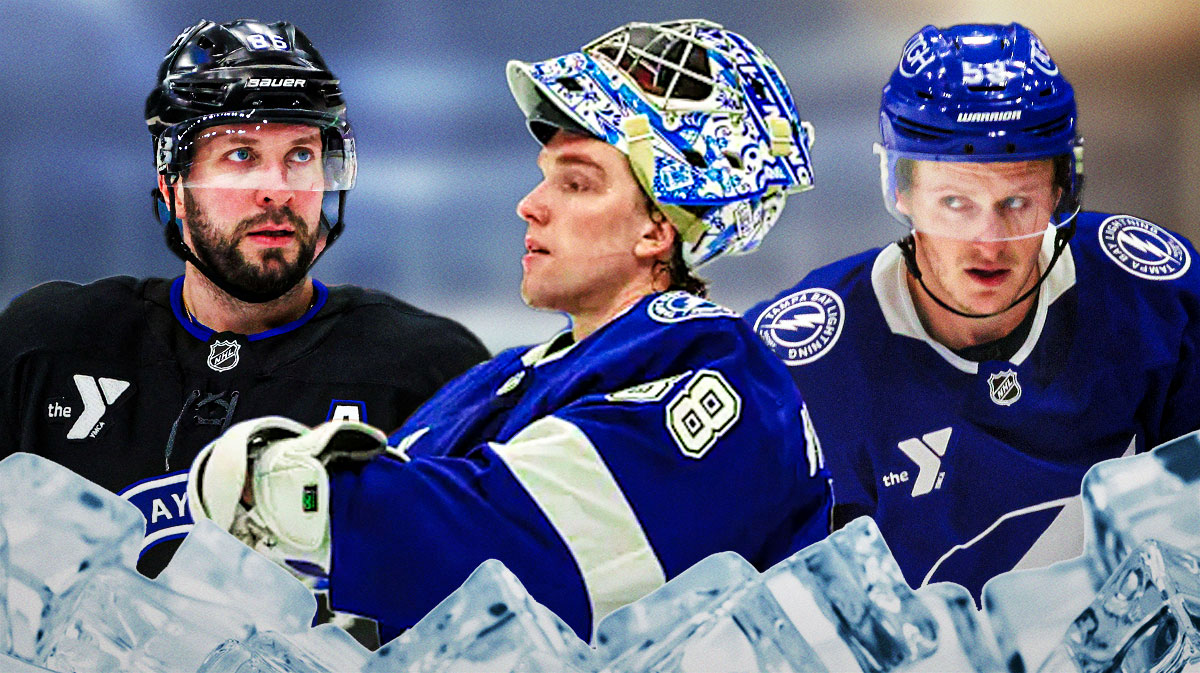 Nikita Kucherov and Jake Guentzel on either side, Andrei Vasilevskiy in middle, hockey rink in background