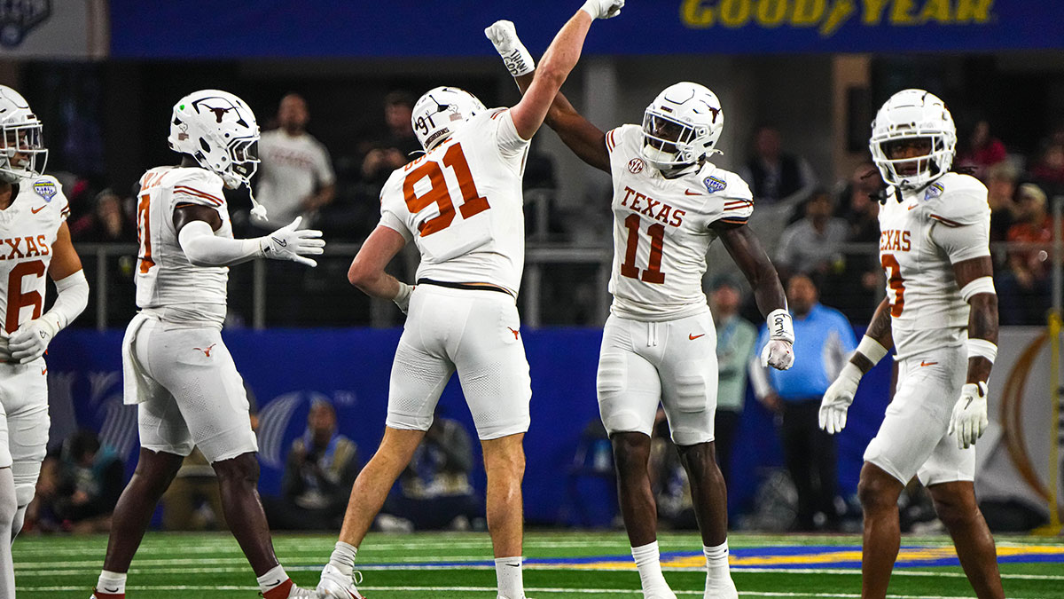 Texas Longhorns edge rushers Colin Simmons (11) and Ethan Burke (91) celebrate a sack during the College Football Playoff semifinal game against Ohio State in the Cotton Bowl at AT&T Stadium on Friday, Jan. 10, 2024 in Arlington, Texas.