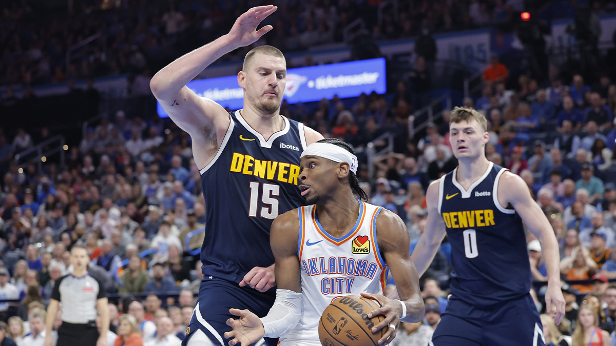 Nuggets center Nikola Jokic (15) defends a drive by Oklahoma City Thunder guard Shai Gilgeous-Alexander (2) during the second half at Paycom Center next to Bucks' Giannis Antetokounmpo