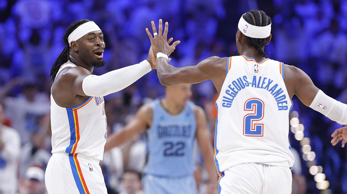 Thunder guard Luguentz Dort (5) high fives guard Shai Gilgeous-Alexander (2) after scoring a three point basket against the Memphis Grizzlies during the second half at Paycom Center with Grizzlies' Ja Morant next to them