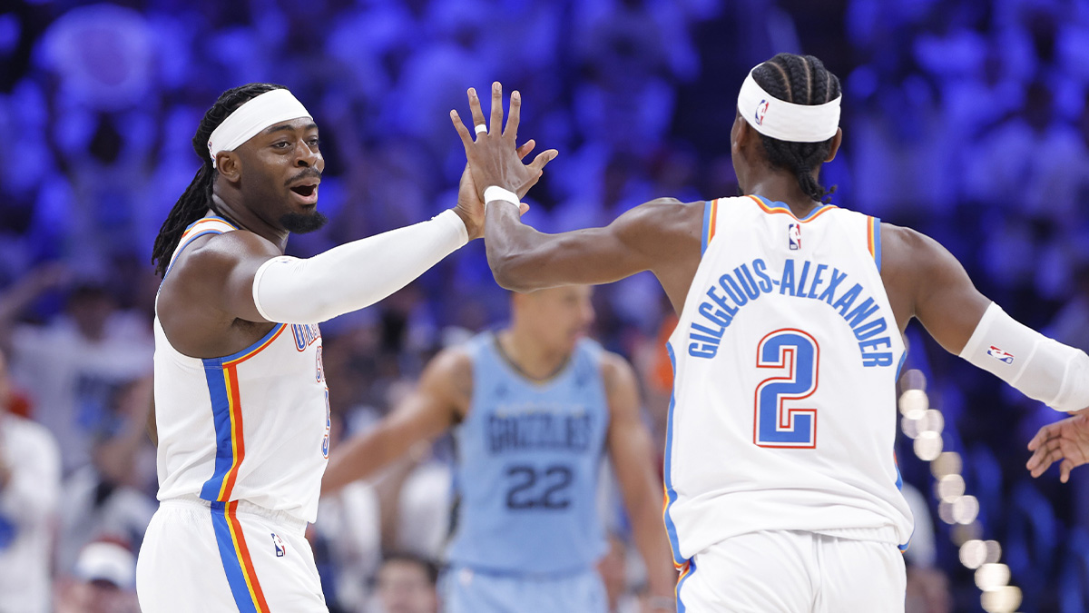 Thunder guard Luguentz Dort (5) high fives guard Shai Gilgeous-Alexander (2) after scoring a three point basket against the Memphis Grizzlies during the second half at Paycom Center.