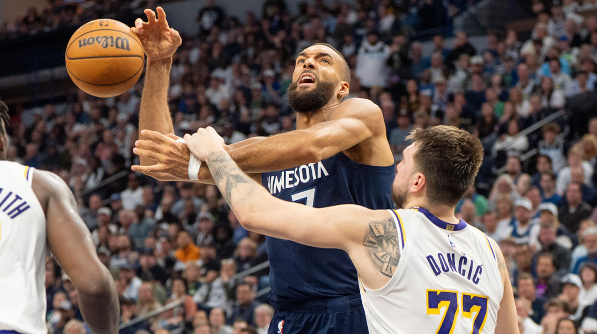 Minnesota Timberwolves center Rudy Gobert (27) goes up for a basket and is fouled by Los Angeles Lakers guard Luka Doncic (77) in the third quarter during game four of first round for the 2025 NBA Playoffs at Target Center.