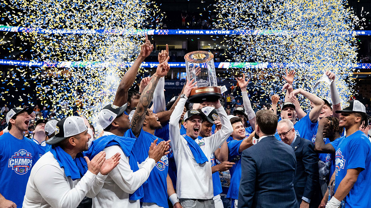 Florida head coach Todd Golden holds his team’s trophy after defeating Tennessee in the Southeastern Conference tournament championship at Bridgestone Arena