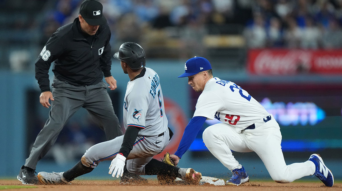 Los Angeles Dodgers second baseman Tommy Edman (25) tags out Miami Marlins shortstop Xavier Edwards (9) during the third inning at Dodger Stadium. Mandatory Credit: Kirby Lee-Imagn Images