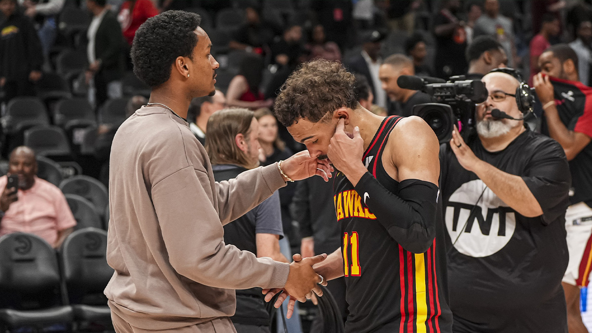 Atlanta Hawks guard Trae Young (11) reacts with injured player Kobe Bufkin after being defeated by the Miami Heat in overtime at State Farm Arena.