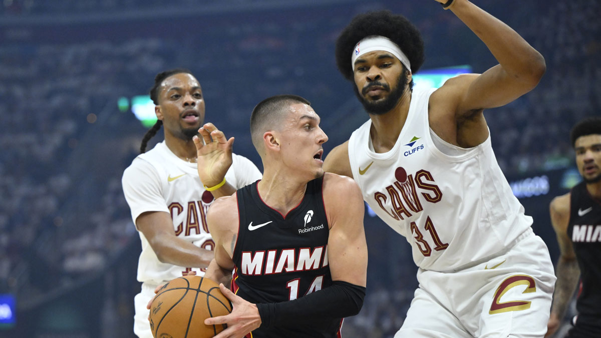Miami Heat guard Tyler Herro (14) dribbles between Cleveland Cavaliers guard Darius Garland (10) and center Jarrett Allen (31) in the first quarter of game two of the first round of the 2025 NBA Playoffs at Rocket Arena.