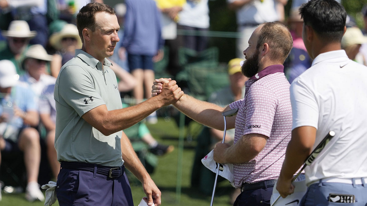Jordan Spieth and Tyrrell Hatton shake hands on the 18th green during the first round of the Masters Tournament