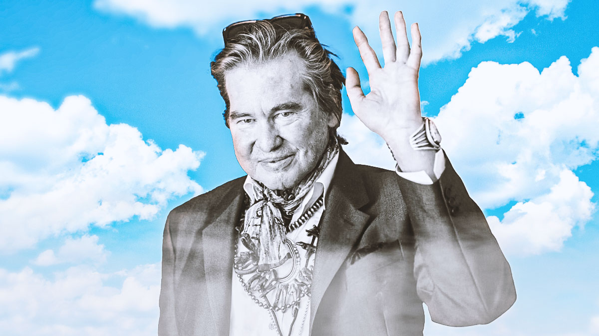 Black and white photo of Batman Forever and Top Gun star Val Kilmer, who died at 65 due to pneumonia, with clouds behind him.