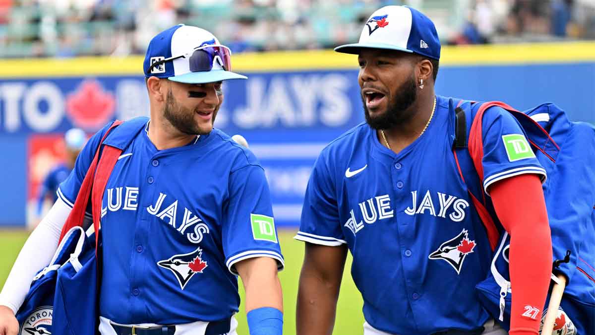 Toronto Blue Jays shortstop Bo Bichette (11) and designated hitter Vladimir Guerrero Jr. (27) walk towards the dugout before a spring training game against the St. Louis Cardinals at TD Ballpark.