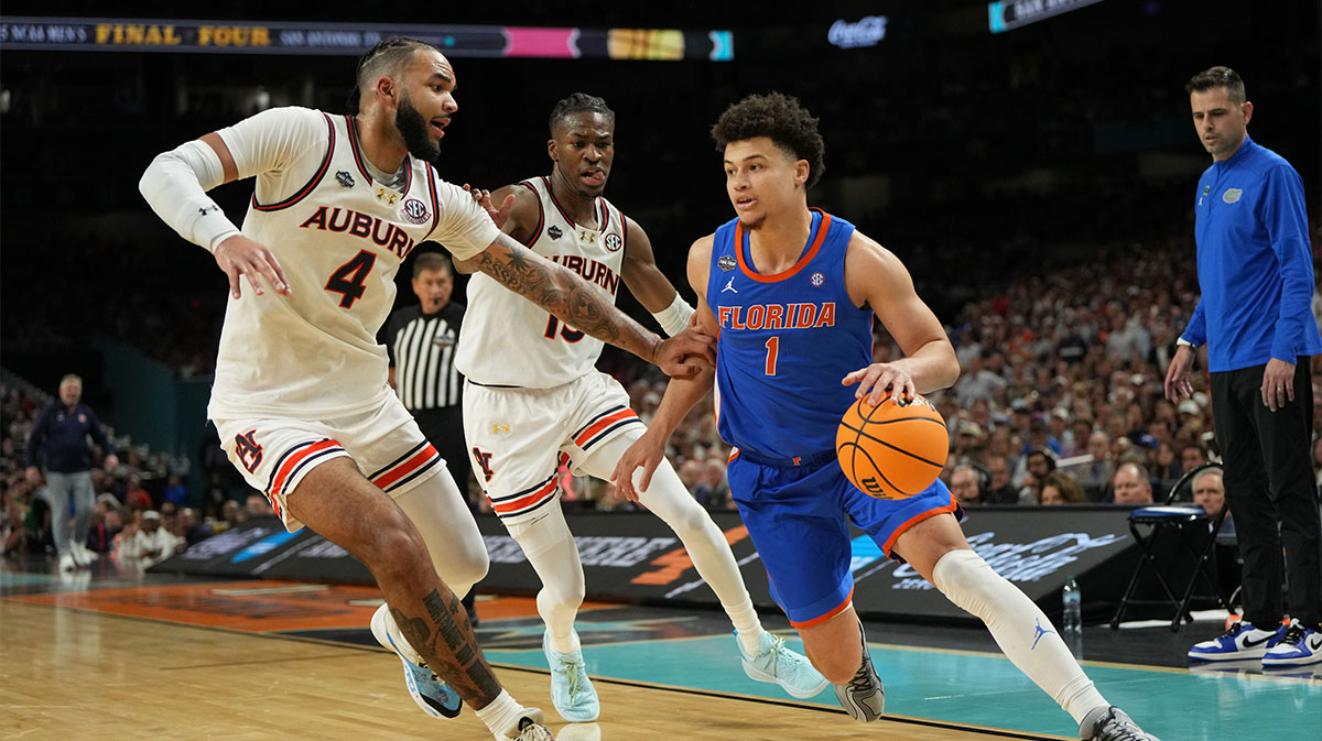 Florida Gators guard Walter Clayton Jr. (1) dribbles the ball against Auburn Tigers forward Johni Broome (4) during the second half in the semifinals of the men's Final Four of the 2025 NCAA Tournament at the Alamodome.