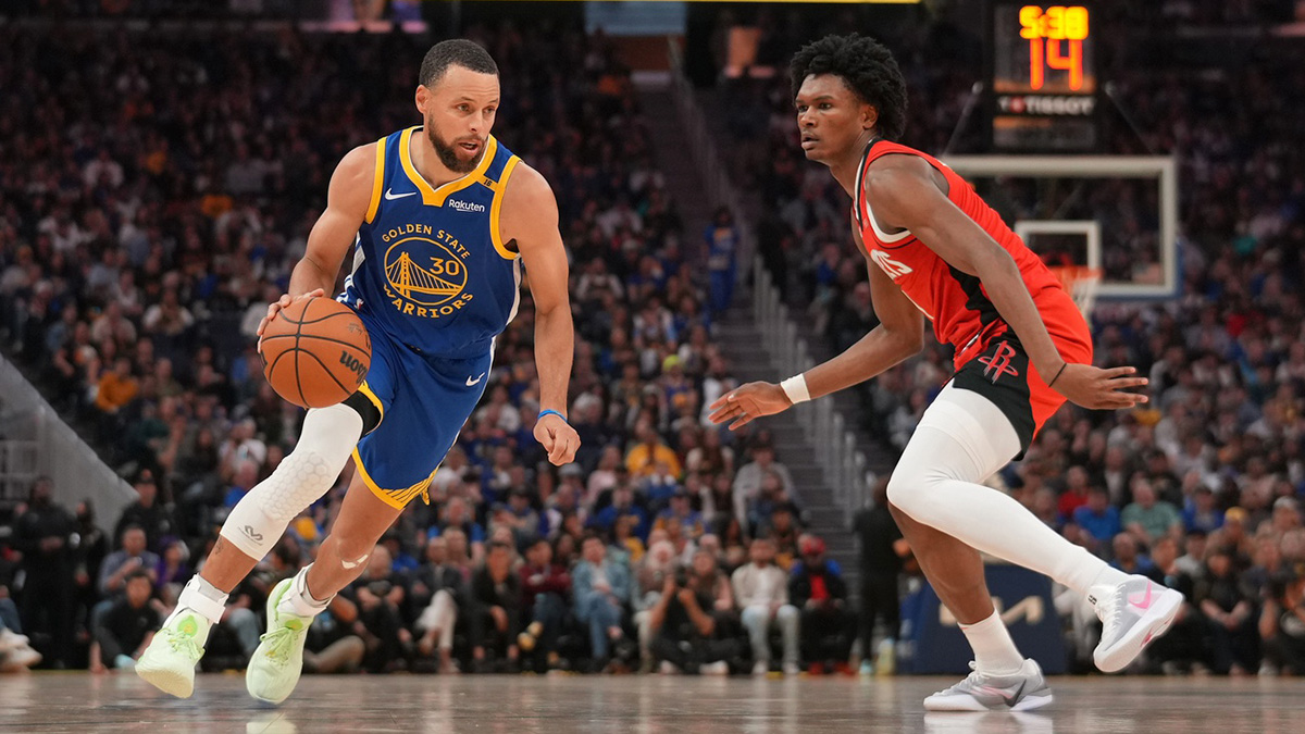 Warriors guard Stephen Curry (30) dribbles past Houston Rockets forward Amen Thompson (1)