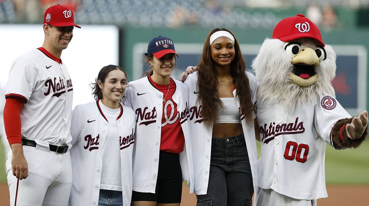 Washington Nationals pitcher Jackson Rutledge (79), Washington Mystics draft picks Georgia Amorre, Sonia Citron, and Kiki Iriafen, and Nationals mascot Screetch, pose for a picture after participating in a first pitch ceremony prior to the Nationals game against the Baltimore Orioles at Nationals Park.