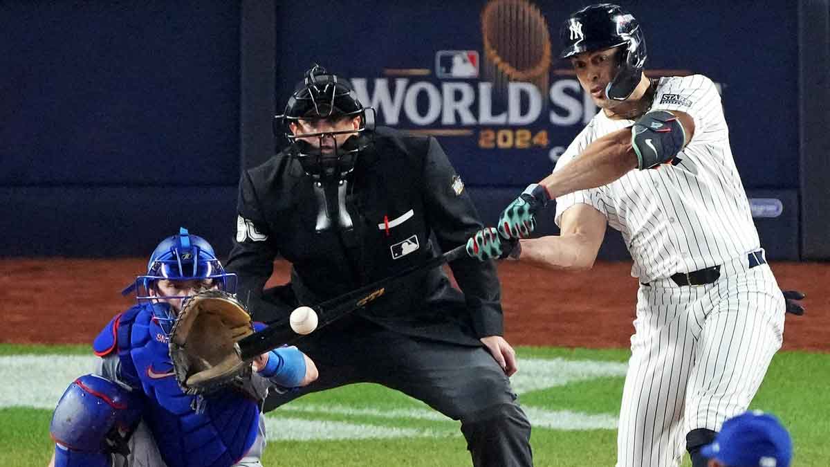New York Yankees designated hitter Giancarlo Stanton (27) hits an RBI sacrifice fly during the sixth inning against the Los Angeles Dodgers in game four of the 2024 MLB World Series at Yankee Stadium.
