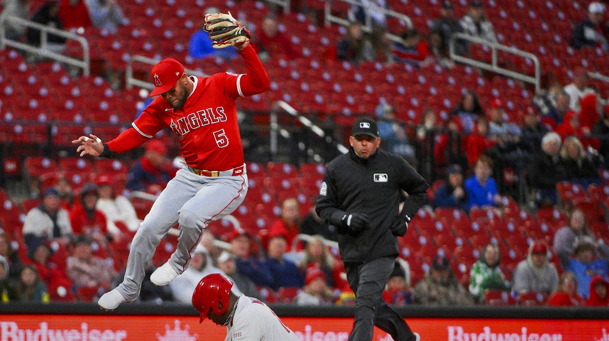 Apr 1, 2025; St. Louis, Missouri, USA; Los Angeles Angels third baseman Yoan Moncada (5) leaps over St. Louis Cardinals right fielder Jordan Walker (18) as he steals third base during the second inning at Busch Stadium.