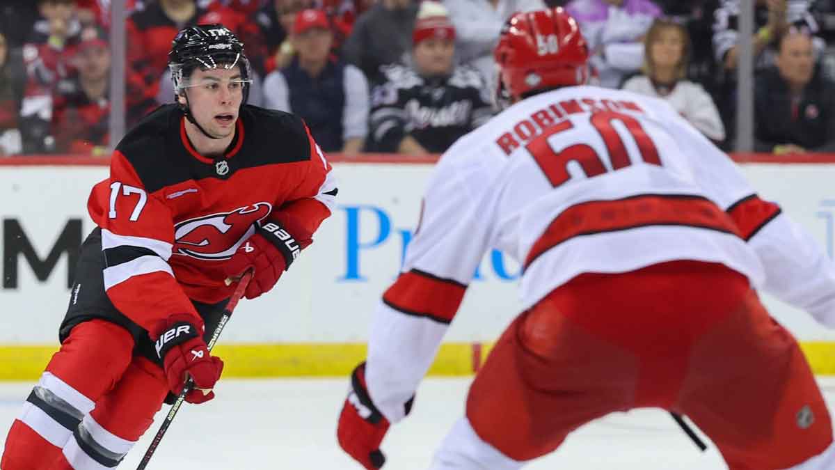 New Jersey Devils defenseman Simon Nemec (17) skates with the puck as Carolina Hurricanes left wing Eric Robinson (50) defends during the first overtime in game three of the first round of the 2025 Stanley Cup Playoffs at Prudential Center.