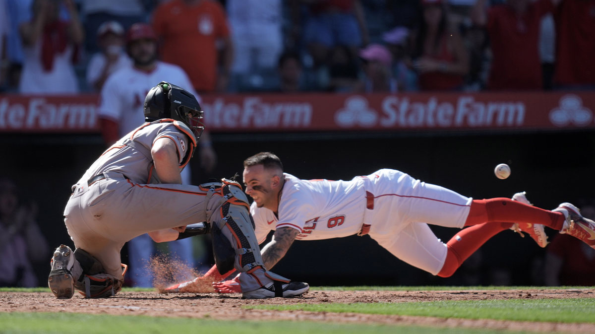 Los Angeles Angels shortstop Zach Neto (9) beats a throw to San Francisco Giants catcher Sam Huff (23) to score on a walk-off double by center fielder Jo Adell (not pictured) at Angel Stadium.