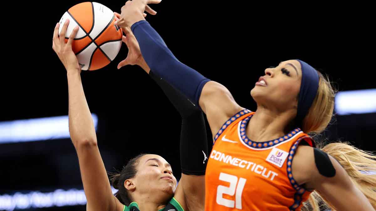 Minnesota Lynx forward Napheesa Collier (24) and Connecticut Sun guard DiJonai Carrington (21) jump for a pass during the second half of game two of the 2024 WNBA Semi-finals at Target Center.