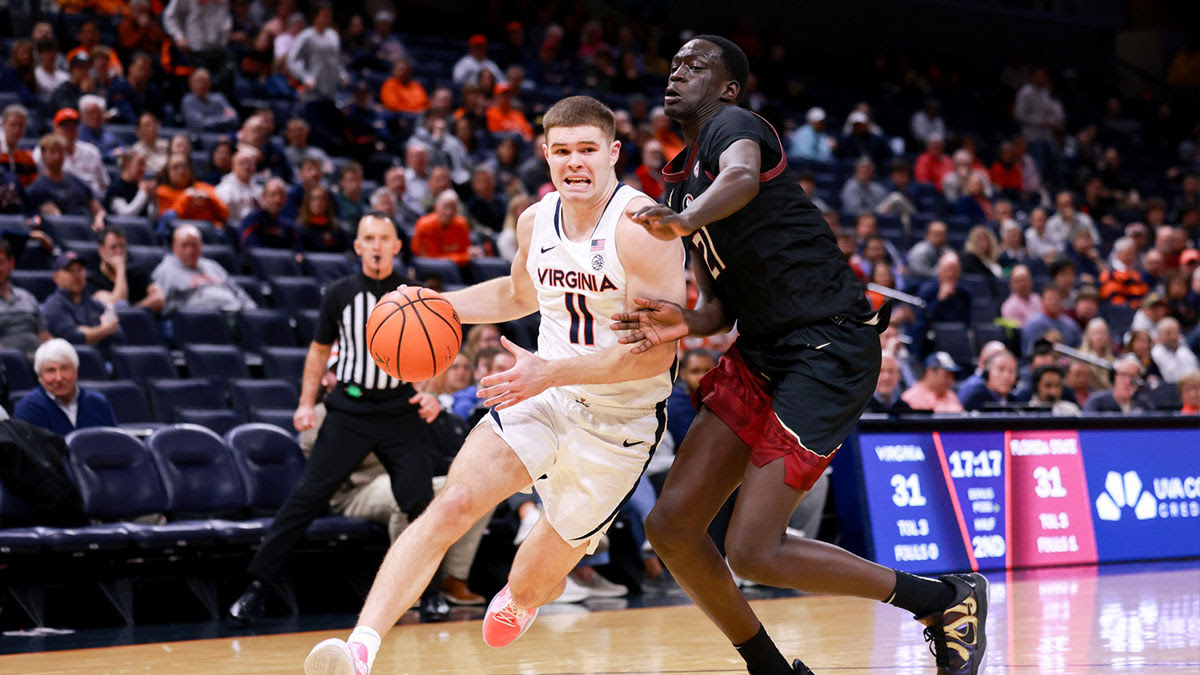 Virginia Cavaliers guard Isaac McKneely (11) dribbles the ball as Florida State Seminoles forward Alier Maluk (21) defends in the second half at John Paul Jones Arena.