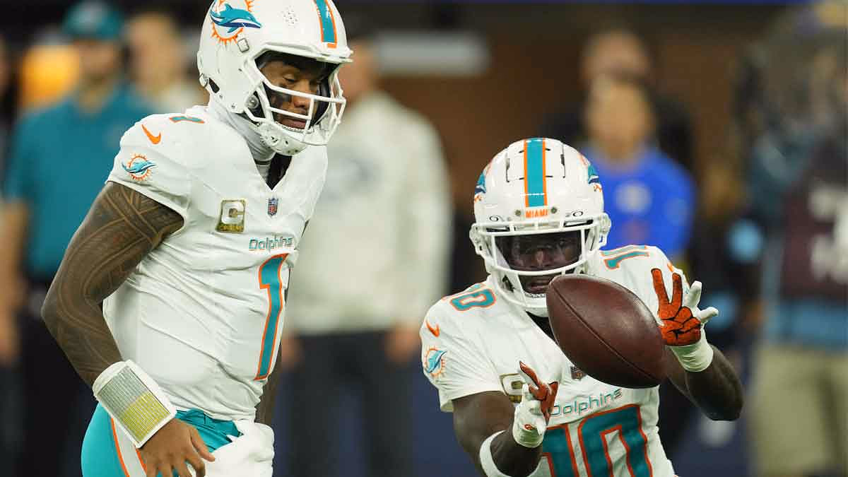 Miami Dolphins quarterback quarterback Tua Tagovailoa (1) pitches the ball to wide receiver Tyreek Hill (10) against the Los Angeles Rams in the second half at SoFi Stadium.