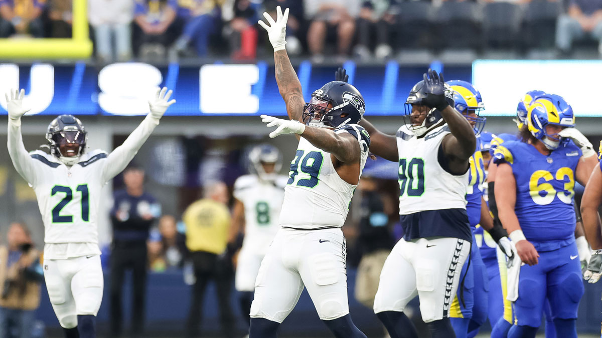 Seattle Seahawks Defensive End Leonard Williams (99), Free Safety Devon Witherspoon (21) and Nose Tackle Jarred Reed (90) celebrate a 4th down stop at SoFi Stadium, as the Seattle Seahawks face off versus the Los Angeles Rams Week 18 matchup.