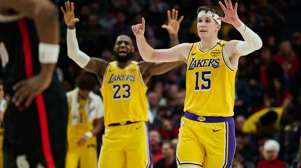 Los Angeles Lakers guard Austin Reaves (15) and forward LeBron James (23) signal to teammates during the second half against the Portland Trail Blazers at Moda Center.
