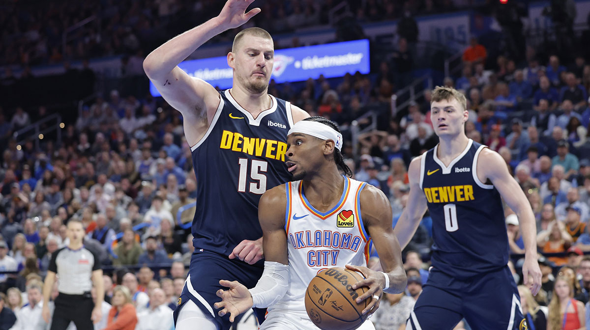Denver Nuggets center Nikola Jokic (15) defends a drive by Oklahoma City Thunder guard Shai Gilgeous-Alexander (2) during the second half at Paycom Center.