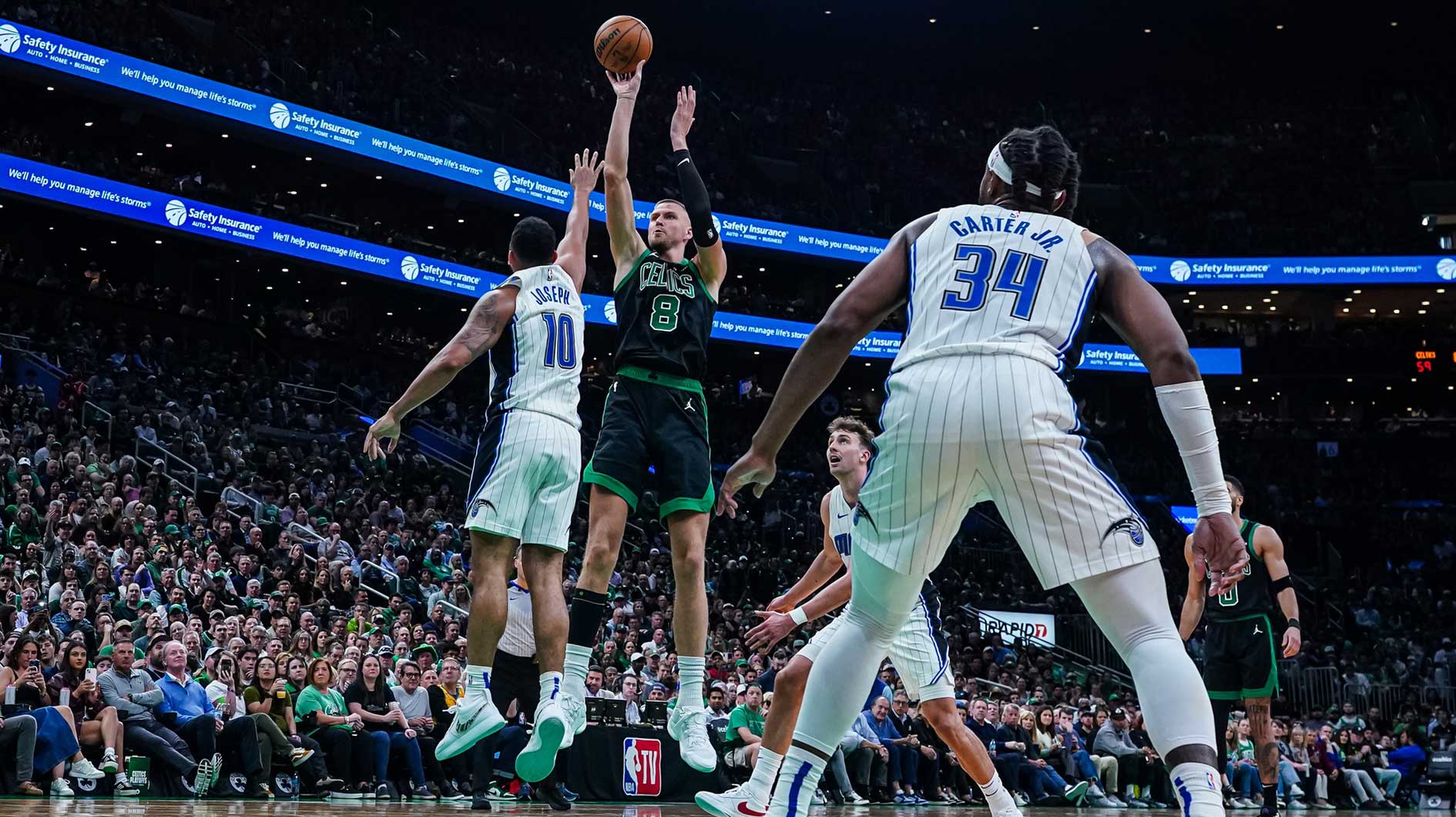 Boston Celtics center Kristaps Porzingis (8) shoots the ball against the Orlando Magic in the third quarter during game five of first round for the 2025 NBA Playoffs at TD Garden.