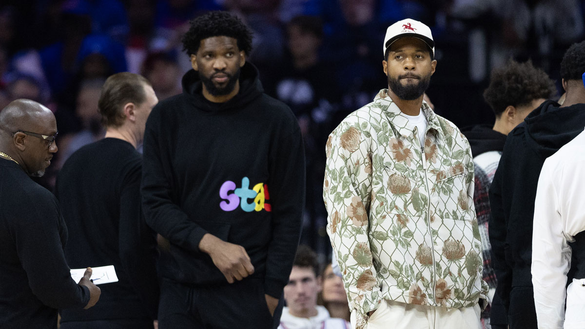 Injured Philadelphia 76ers Paul George (R) and Joel Embiid (L) look on during the first quarter against the Memphis Grizzlies at Wells Fargo Center.