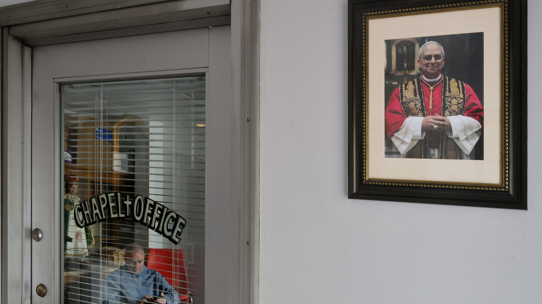 A newly installed photo of Pope Leo XIV hangs on the walls at the entrance to Our Lady's Chapel in downtown New Bedford, in the background Franciscan Father Andre is seen in the chapel office. Mandatory Credit: © PETER PEREIRA/The Standard-Times / USA TODAY NETWORK via Imagn Images