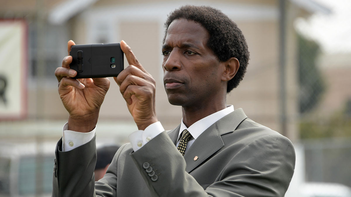 NBA former player A.C. Green takes photos with a cell phone during the unveiling of the David Beckham Community Soccer Field at The Salvation Army Red Shield Youth and Community Center.