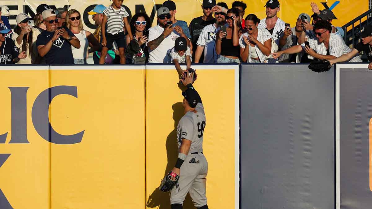 New York Yankees right fielder Aaron Judge (99) gives a ball to a fan against the Tampa Bay Rays in the ninth inning at George M. Steinbrenner Field.