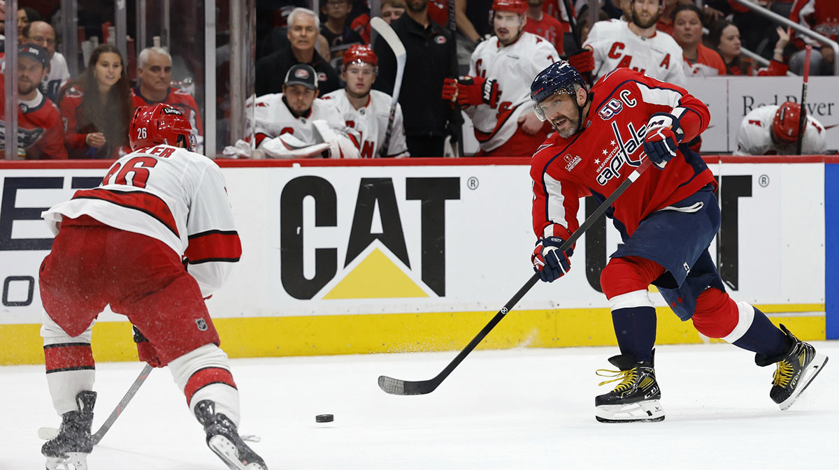 Washington Capitals left wing Alex Ovechkin (8) shoots the puck as Carolina Hurricanes defenseman Sean Walker (26) defends in the third period in game five of the second round of the 2025 Stanley Cup Playoffs at Capital One Arena