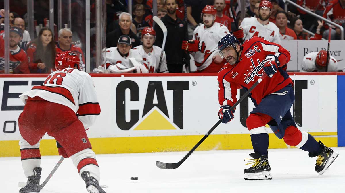 Washington Capitals left wing Alex Ovechkin (8) shoots the puck as Carolina Hurricanes defenseman Sean Walker (26) defends in the third period in game five of the second round of the 2025 Stanley Cup Playoffs at Capital One Arena.