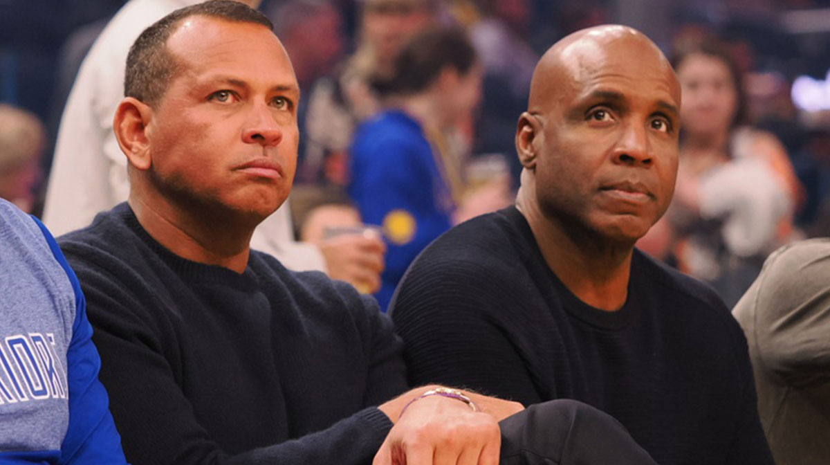 Retired baseball players Alex Rodriguez (left) and Barry Bonds (right) sit court side before the game between the Golden State Warriors and Minnesota Timberwolves at Chase Center.