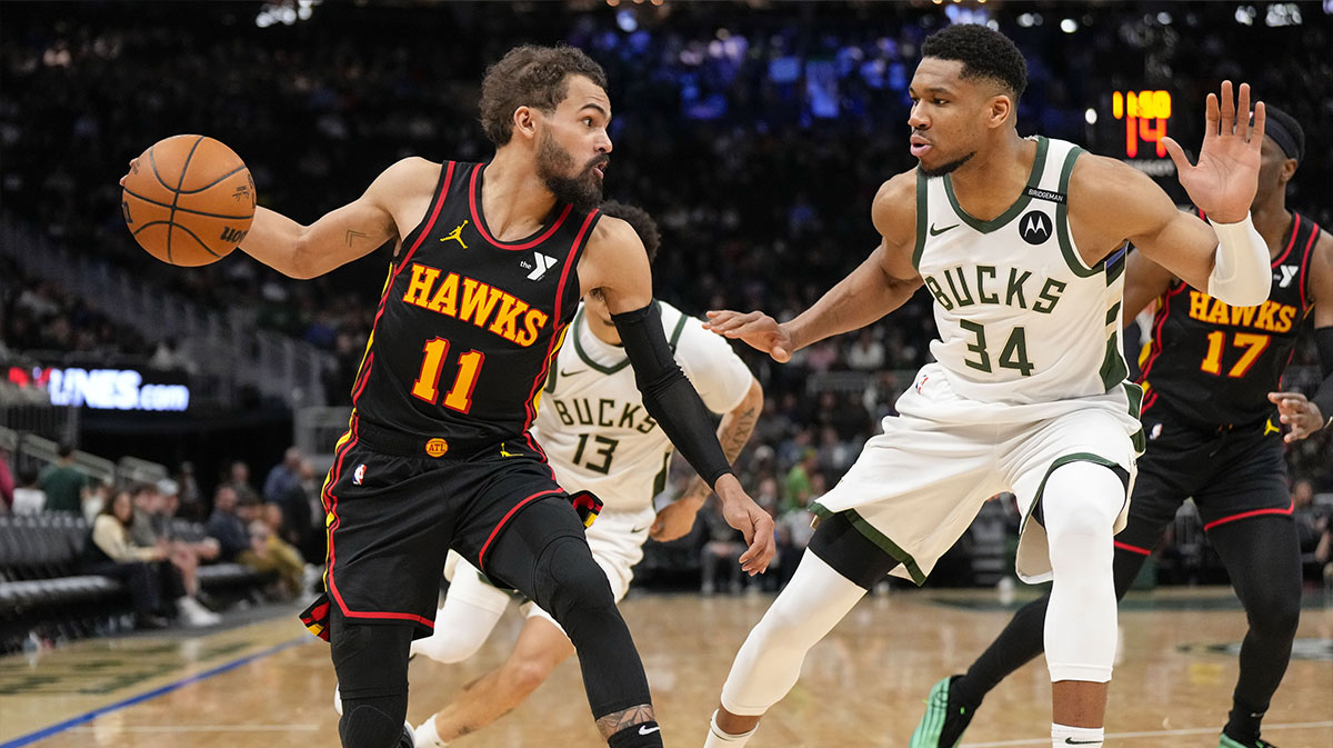 Atlanta Hawks guard Trae Young (11) dribbles the ball under pressure from Milwaukee Bucks forward Giannis Antetokounmpo (34) during the third quarter at Fiserv Forum.