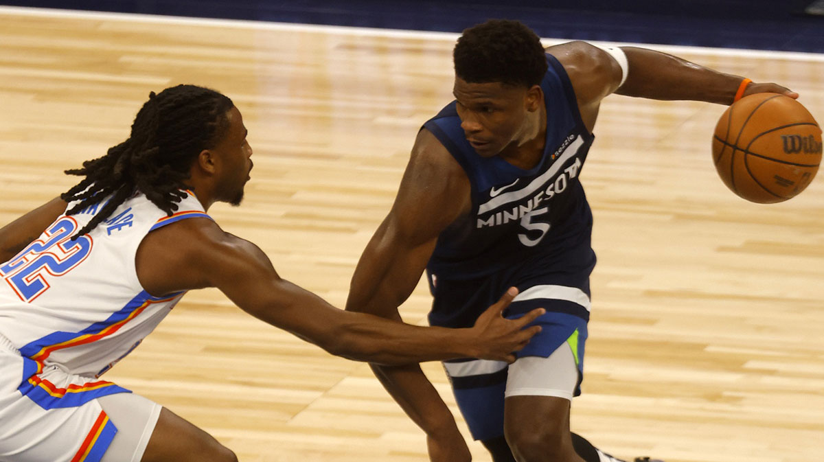 Minnesota Timberwolves guard Anthony Edwards (5) dribbles the ball against Oklahoma City Thunder guard Cason Wallace (22) during the first half in game three of the western conference finals for the 2025 NBA Playoffs at Target Center.
