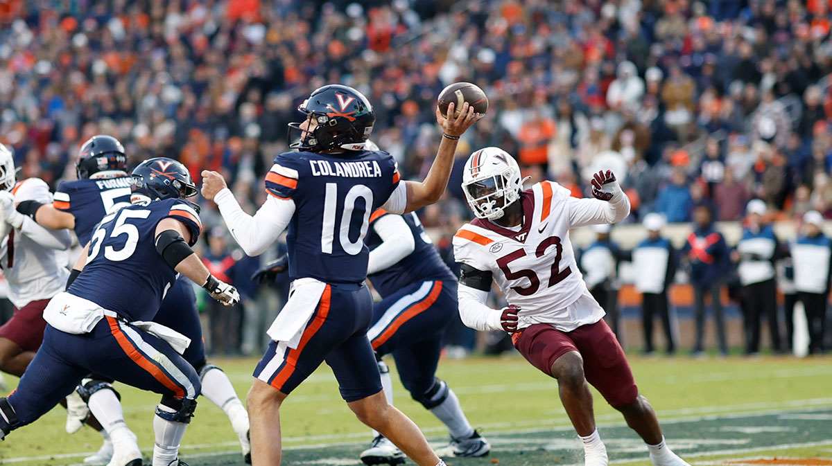 Virginia Cavaliers quarterback Anthony Colandrea (10) passes the ball from his own end zone as Virginia Tech Hokies defensive lineman Antwaun Powell-Ryland (52) chases during the second quarter at Scott Stadium.