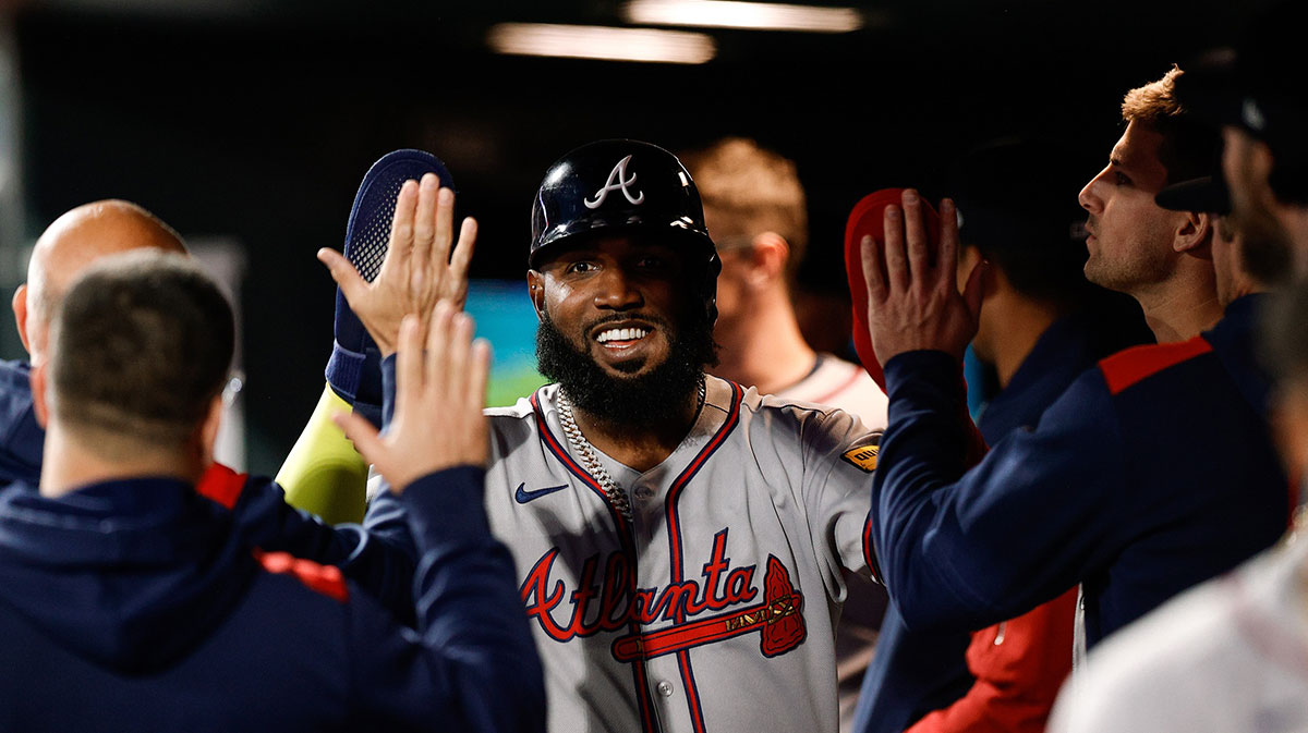 Atlanta Braves designated hitter Marcell Ozuna (20) celebrates in the dugout after being driven in on an RBI in the fifth inning against the Colorado Rockies at Coors Field.