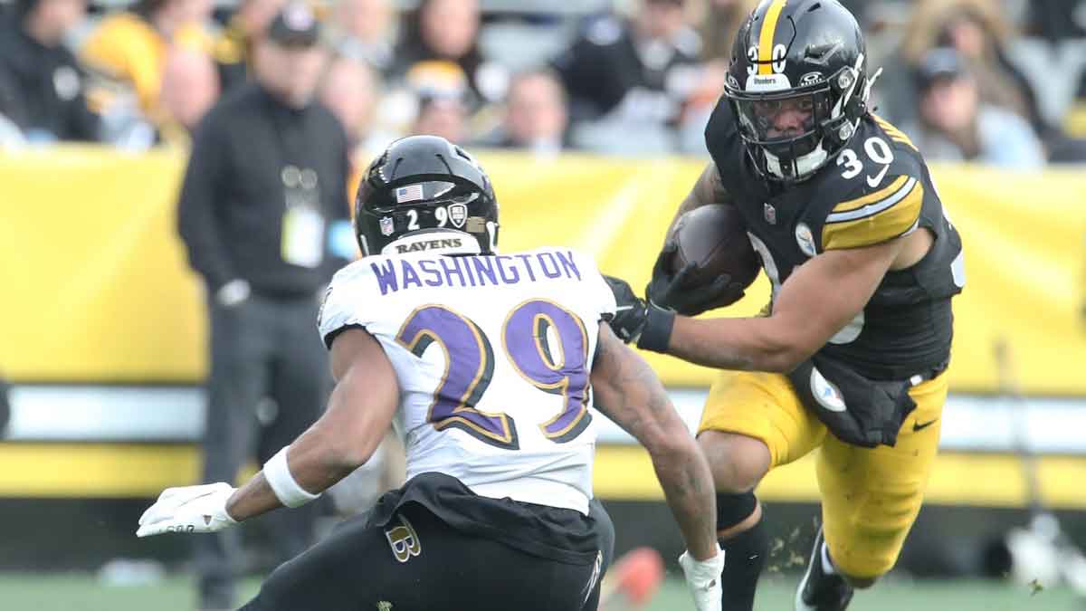 Pittsburgh Steelers running back Jaylen Warren (30) carries the ball against Baltimore Ravens safety Ar'Darius Washington (29) during the third quarter at Acrisure Stadium.