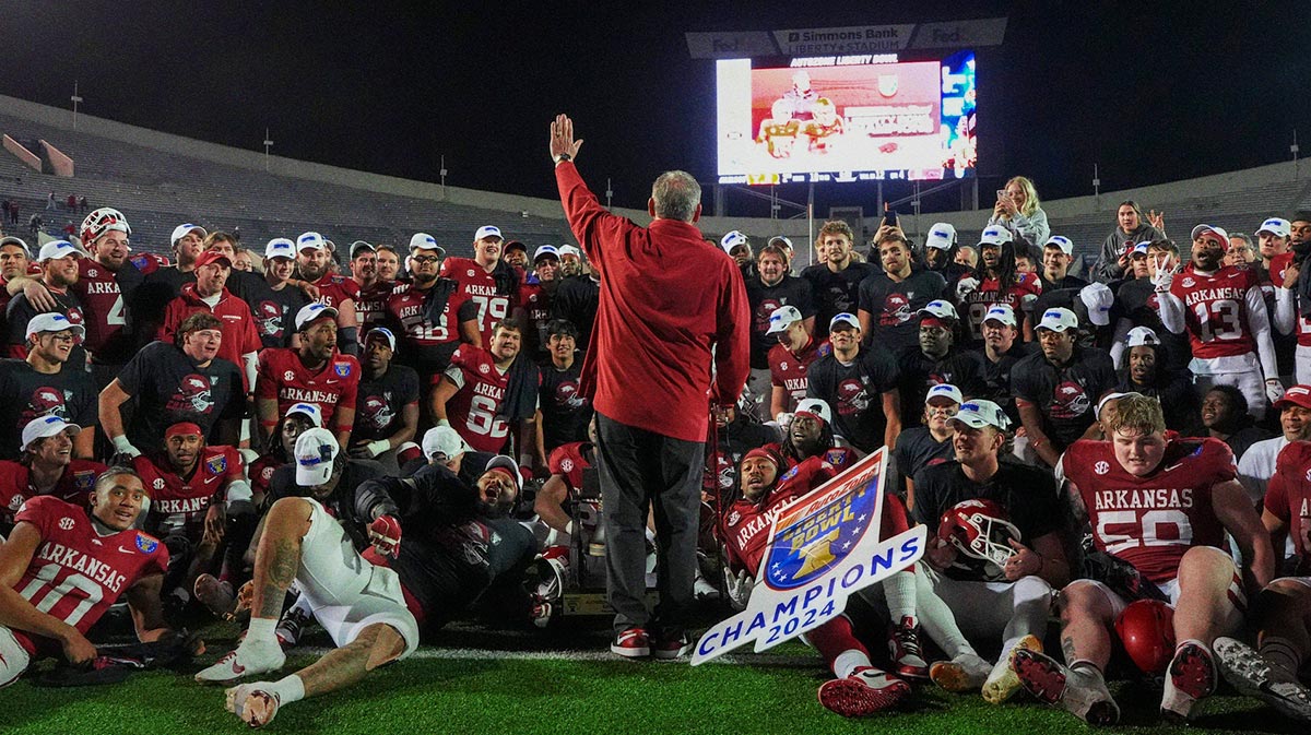 Arkansas' head coach Sam Pittman leads a chant with his team before they pose for a photo after Arkansas defeated Texas Tech 36-26 in the AutoZone Liberty Bowl