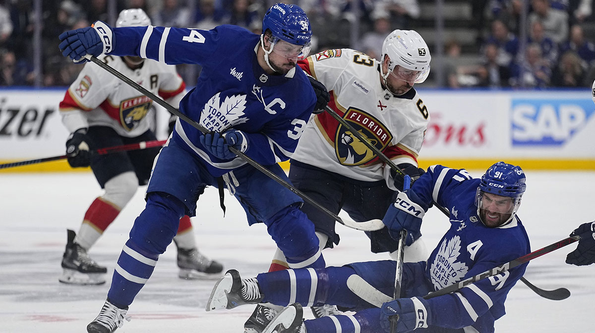 Toronto Maple Leafs forward Auston Matthews (34) and forward John Tavares (91) and Florida Panthers forward Brad Marchand (63) battle for a puck during the second period of game five of the second round of the 2025 Stanley Cup Playoffs at Scotiabank Arena.