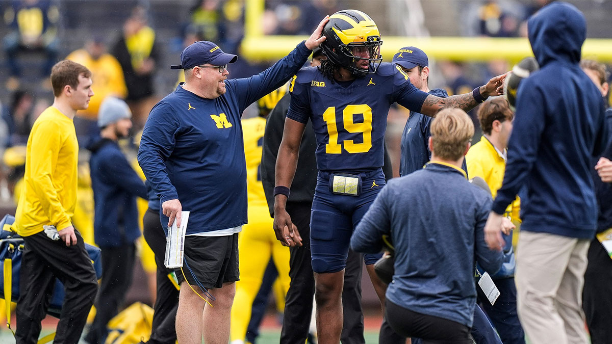 Michigan tight ends coach Steve Casula, left, talks to quarterback Bryce Underwood (19) at warm up before the spring game at Michigan Stadium